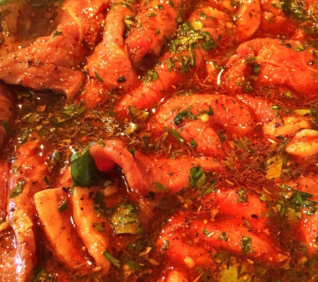 Carne Asada meat in a bowl with the marinade.