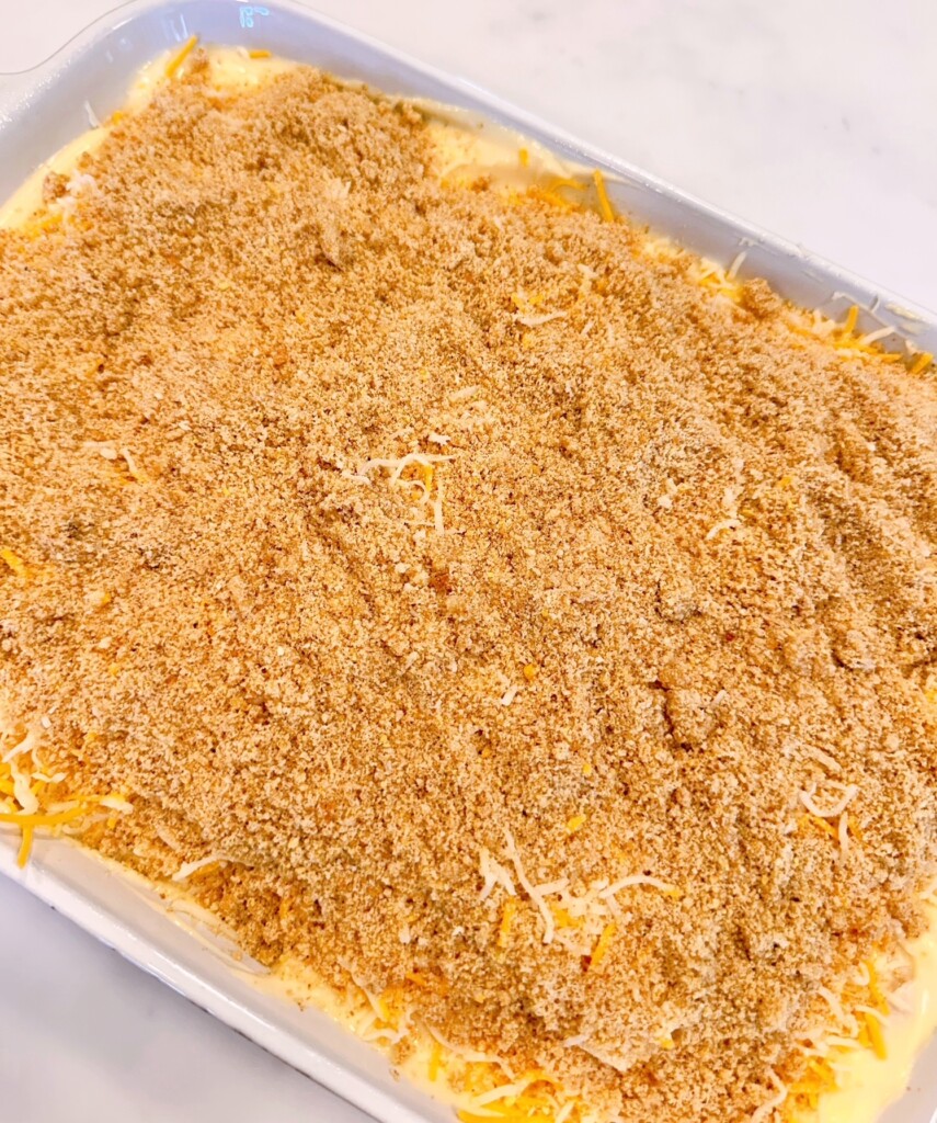 Breadcrumbs on top of cheese in casserole dish.