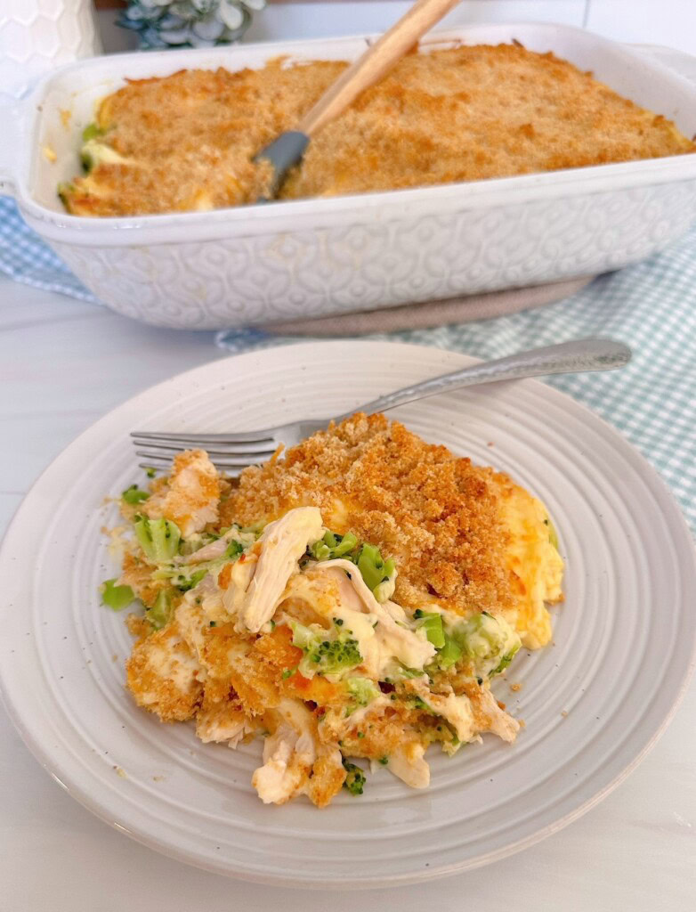 Chicken Broccoli Casserole in a casserole dish with a single serving on a plate in front.