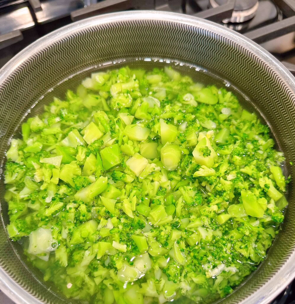 Broccoli in a sauce pan on the stove.