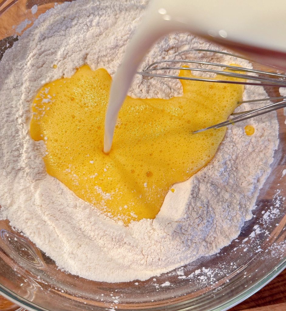 Adding milk to waffle mix dry ingredients.