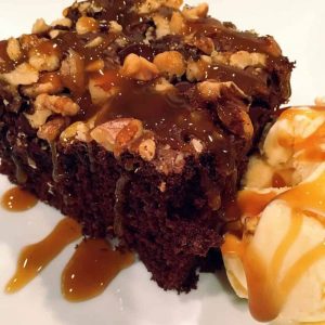 Chocolate Chip Walnut Cake with caramel sauce on a plate