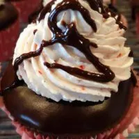 chocolate cupcake with frosting and a cherry in the middle