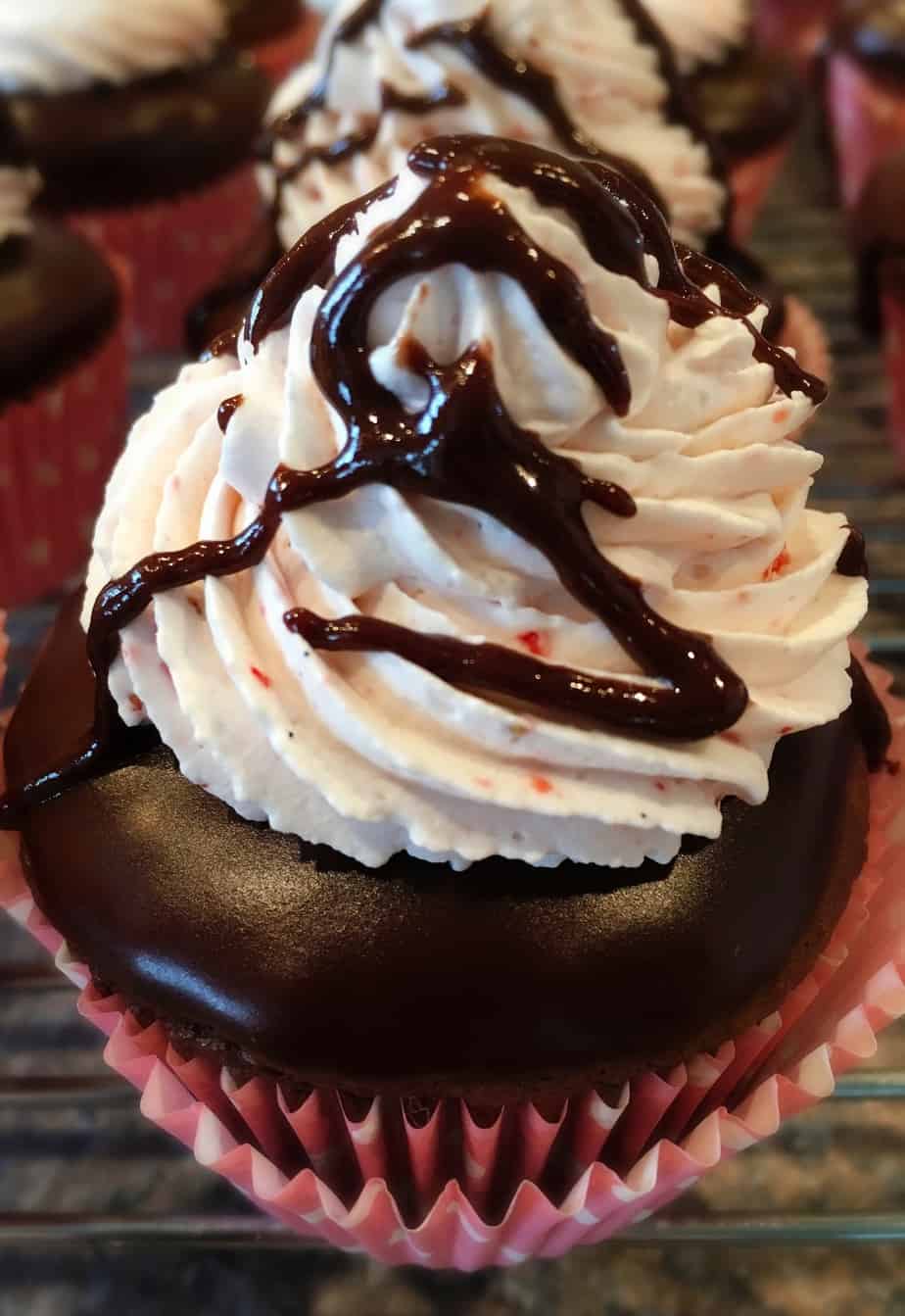 chocolate cupcake with frosting and a cherry in the middle