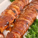 Pork Tenderloin sliced and arranged on a white serving platter.