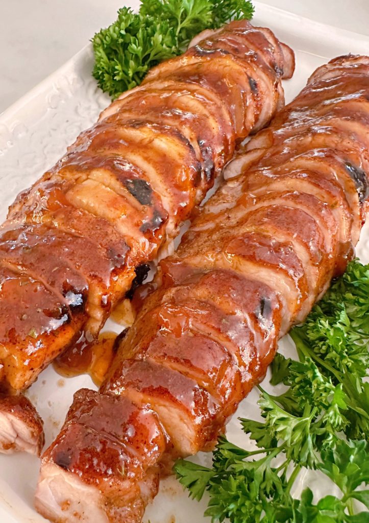 Pork Tenderloin sliced and arranged on a white serving platter.