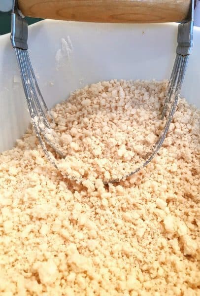 Shortening being cut into flour and salt for a flaky pie crust for Strawberry Rhubarb Pie.