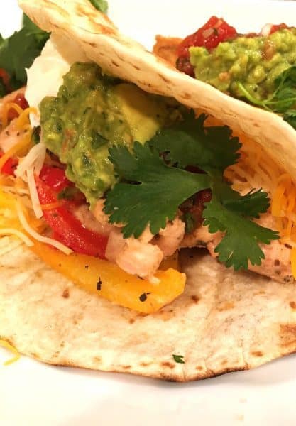 Flour tortilla stuffed with Tangy chicken fajitas and topped off with grated cheese, avocado, and fresh cilantro.