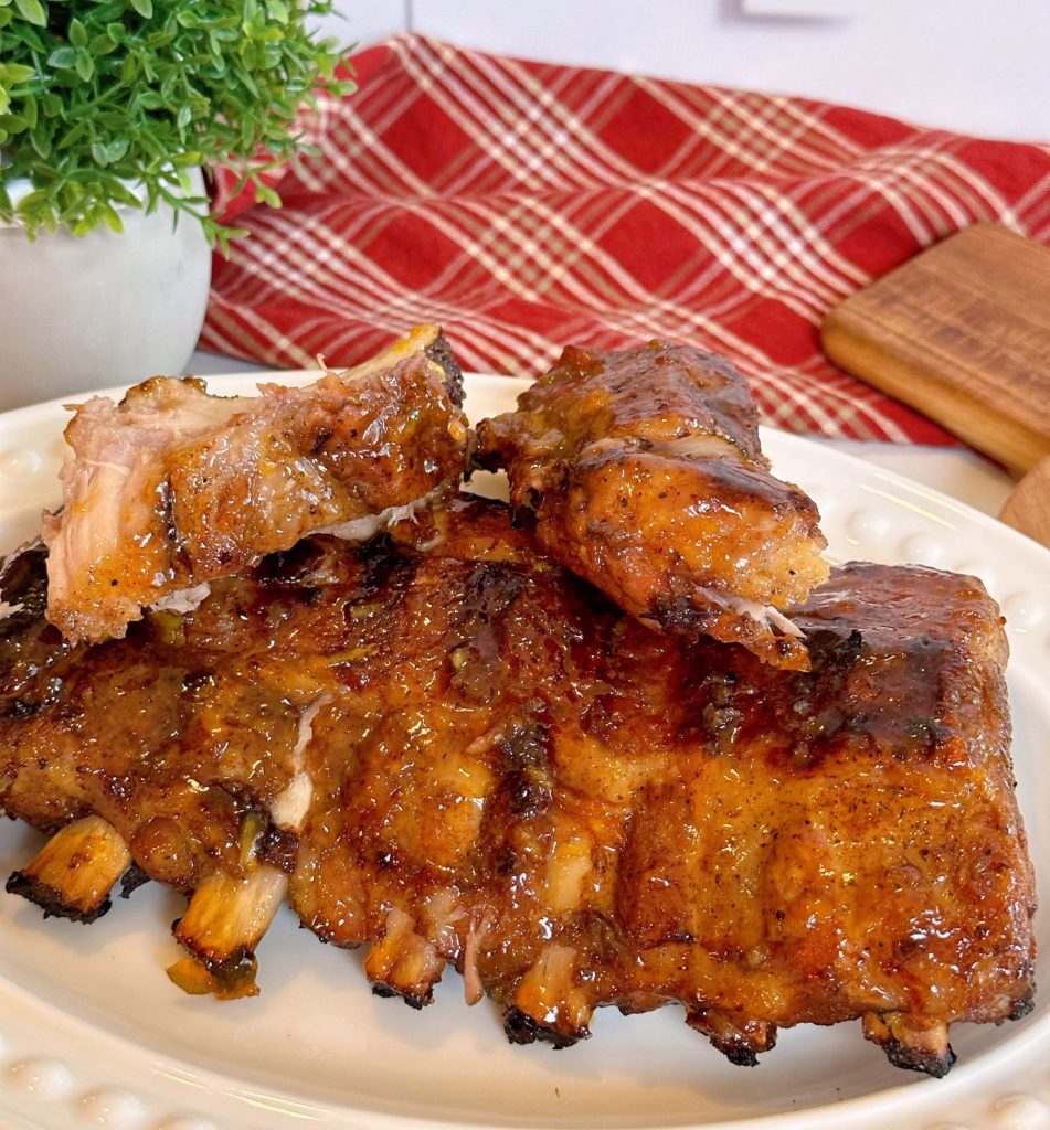 Perfect Grilled Baby Back Pork Ribs slathered in Special Glaze on a white serving dish.