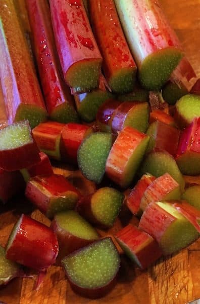 Large bunch of fresh picked rhubarb on a cutting board sliced for Fresh Strawberry Rhubarb Pie.