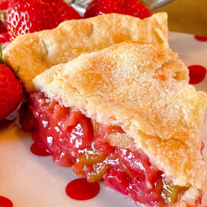 Slice of Strawberry Rhubarb Pie on a polka-dot plate upclose