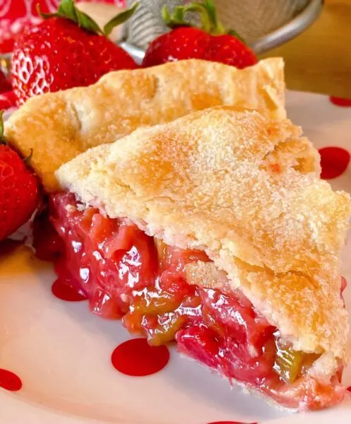 Slice of Strawberry Rhubarb Pie on a polka-dot plate upclose 
