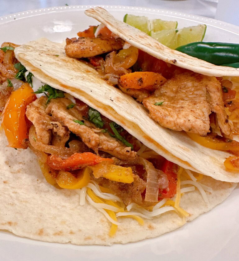 Tangy Chicken Fajitas on a plate with delicious toppings.