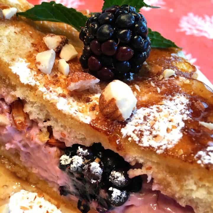 French toast stuffed with berry cream cheese, fresh berries, and sprinkled with powder sugar and toasted almonds. Drizzled with syrup.