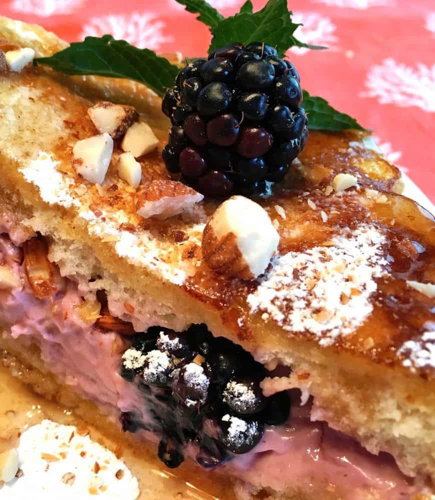 Two pieces of French toast with a blackberry filling in between