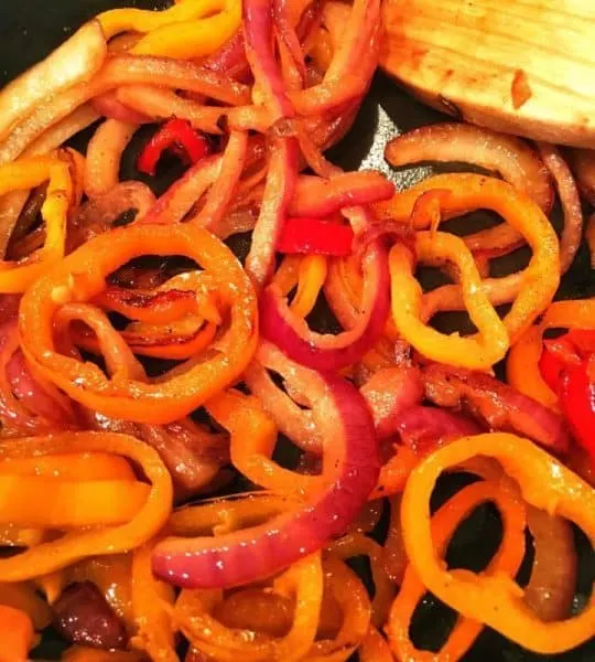 Caramelized onions and peppers in skillet.