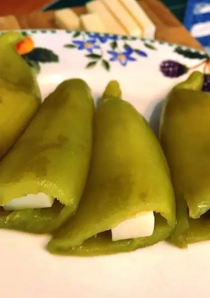 Chili Relleno Peppers stuffed full of Jack cheese laying on a plate waiting to be cooked.