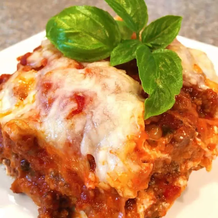 Serving of Eggplant Parmesan on a plate with fresh basil