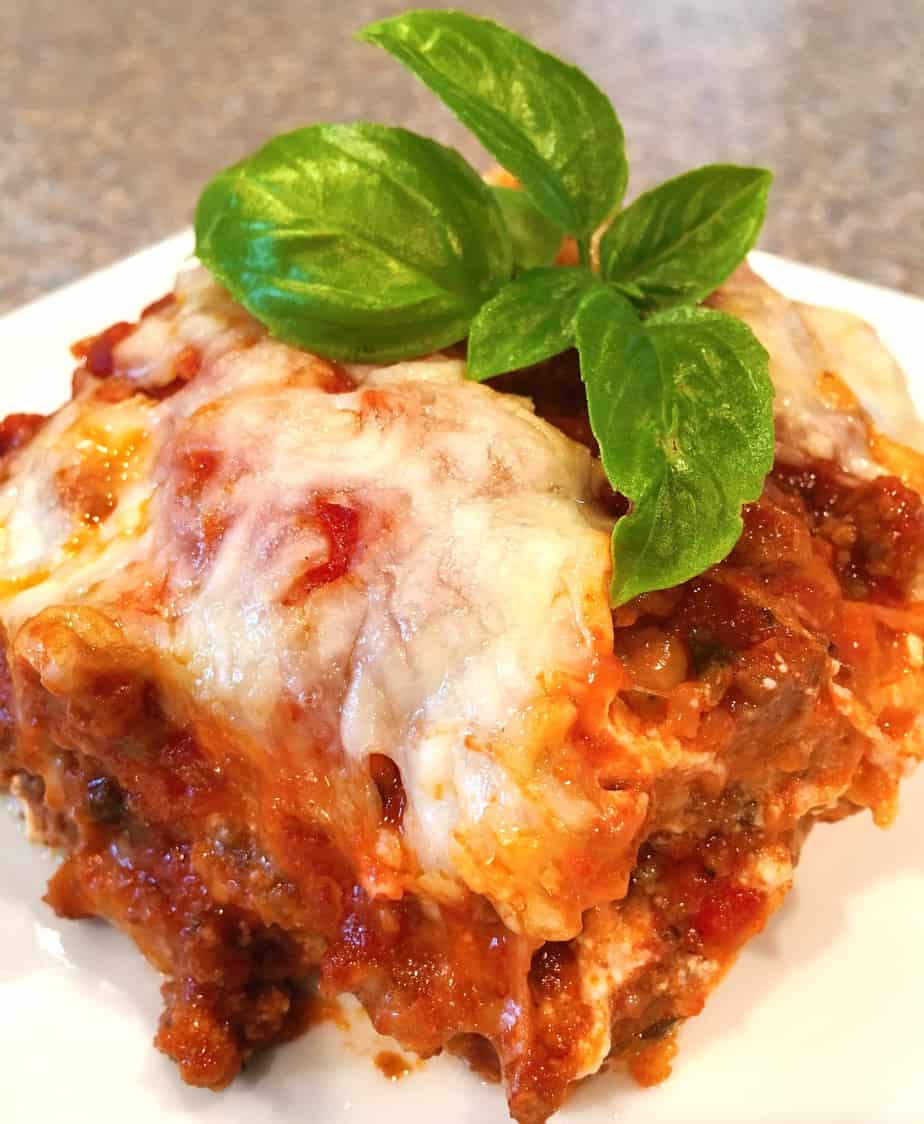 Serving of Eggplant Parmesan on a plate with fresh basil