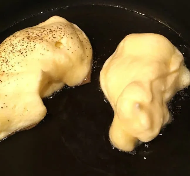 Frying Chili Relleno's in large skillet with vegetable oil. Salted and peppered batter frying waiting to be turned.