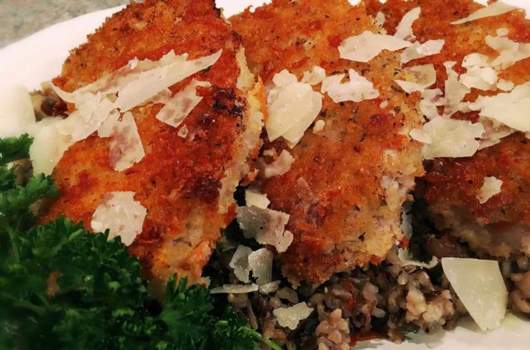 Paremsan Crusted Pork Chops on a bed of Wild Rice and sprinkled with Parmesan Cheese Flakes.