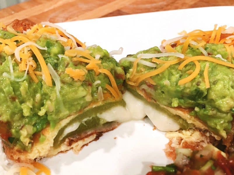 Perfectly Cut Chili Relleno's with cheese melted topped with fresh guacamole and grated cheese. 