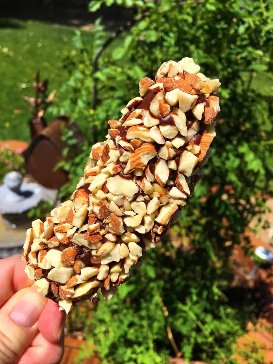 A frozen banana with chocolate and nuts