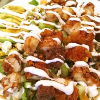 A green salad with cut up boneless buffalo wings