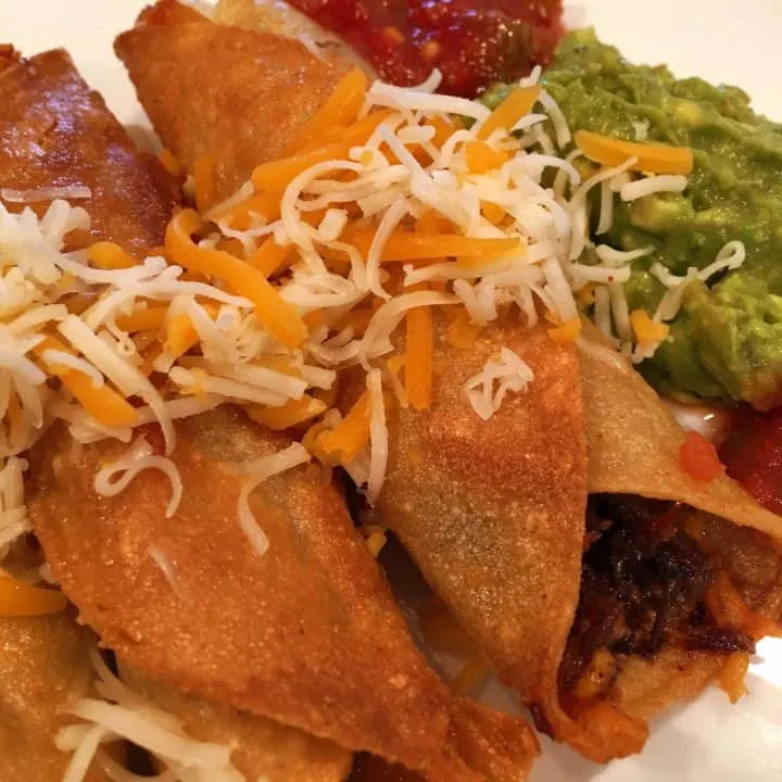 Homemade Taquitos with beef, cheese, sour cream, salsa, and guacamole