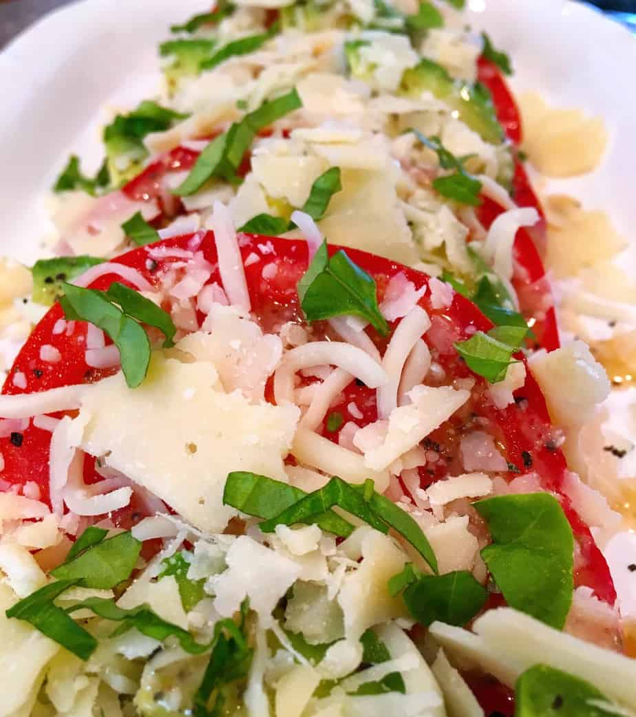 Sliced tomatos with sliced avocado and cheese