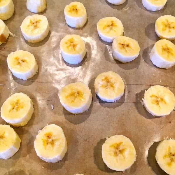 cut up banana's on a wax paper lined baking sheet ready for the freezer