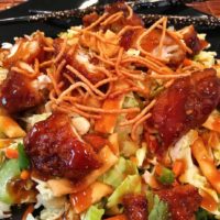 Salad with chicken, vegetables, dried noodles, and an asian sauce