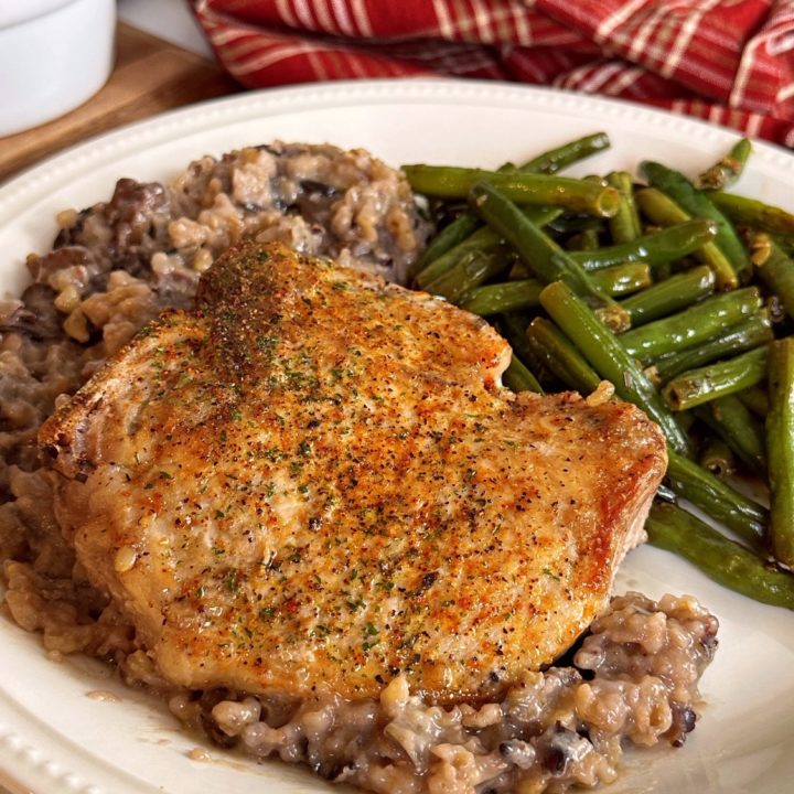 White plate with Minnesota Pork Chop Casserole and fresh green beans.