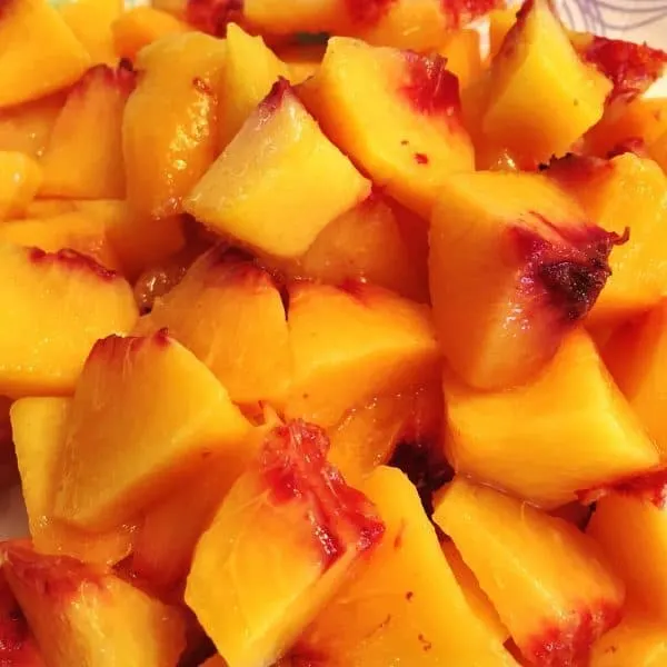 fresh cut up peaches ready for freezing for smoothies
