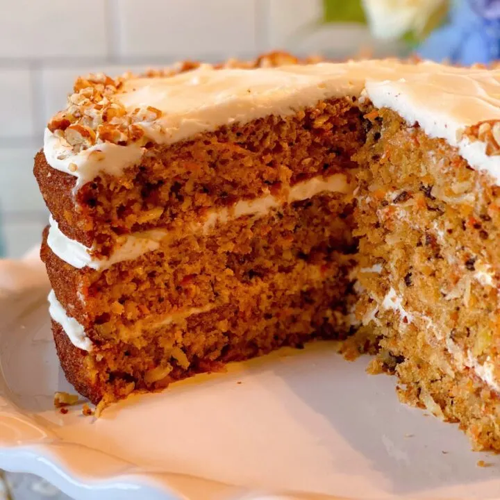 World's Best Carrot Cake on a pedestal with slices gone.