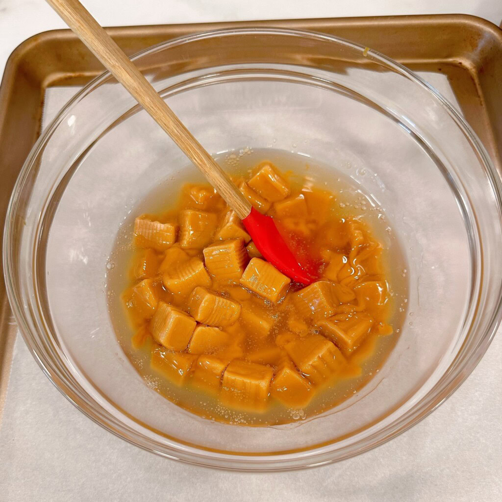 Caramels in a bowl with light corn syrup.