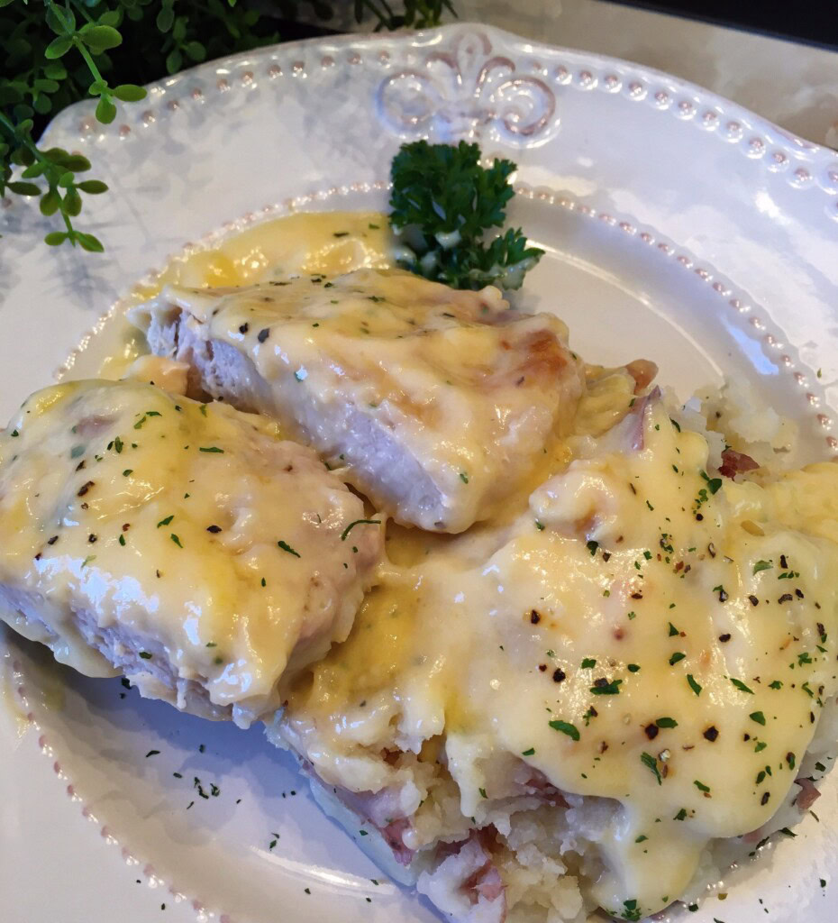 Chicken Fried Pork Chops in the Slow Cooker served over a plate of mashed potatoes.