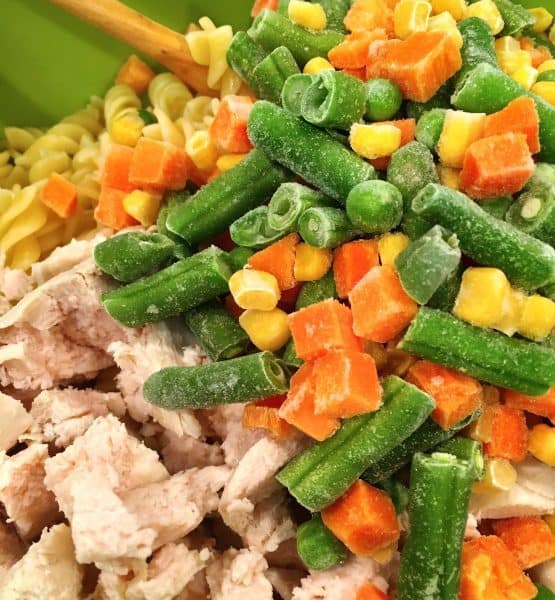 Add one bag frozen mixed vegetables to chicken and noodles in the bowl.