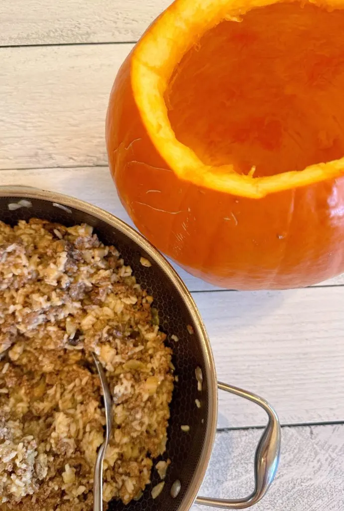 Stuffing the pumpkin with the meat mixture.