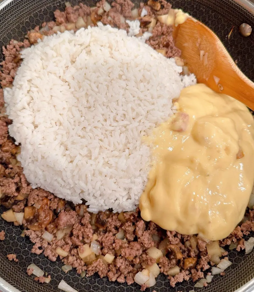 Adding rice and soup mix to meat mixture.