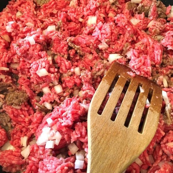 Browning ground beef with onions in skillet