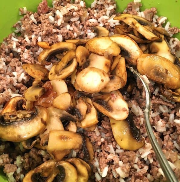 adding rice and mushrooms to stuffing mix for dinner in a pumpkin