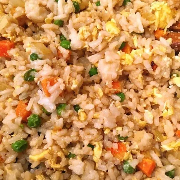 Adding Soy Sauce to rice, eggs, and vegetables for Fried Rice