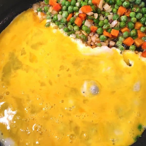 Cooking eggs with mixed vegetables.