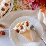 Slice of Pumpkin Chiffon Pie with pecan halves on a dessert plate.