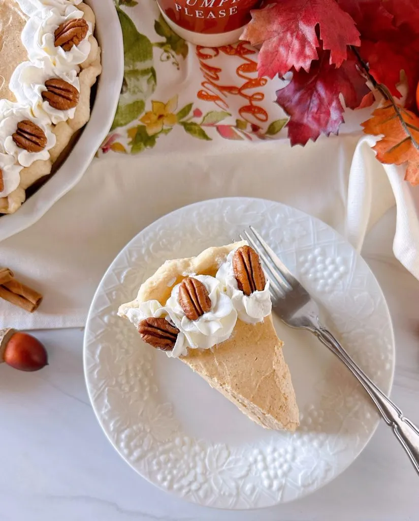 Slice of Pumpkin Chiffon Pie with pecan halves on a dessert plate.