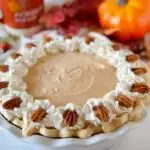 Whole Pumpkin Chiffon Pie with Whipped cream and pecan garnish.