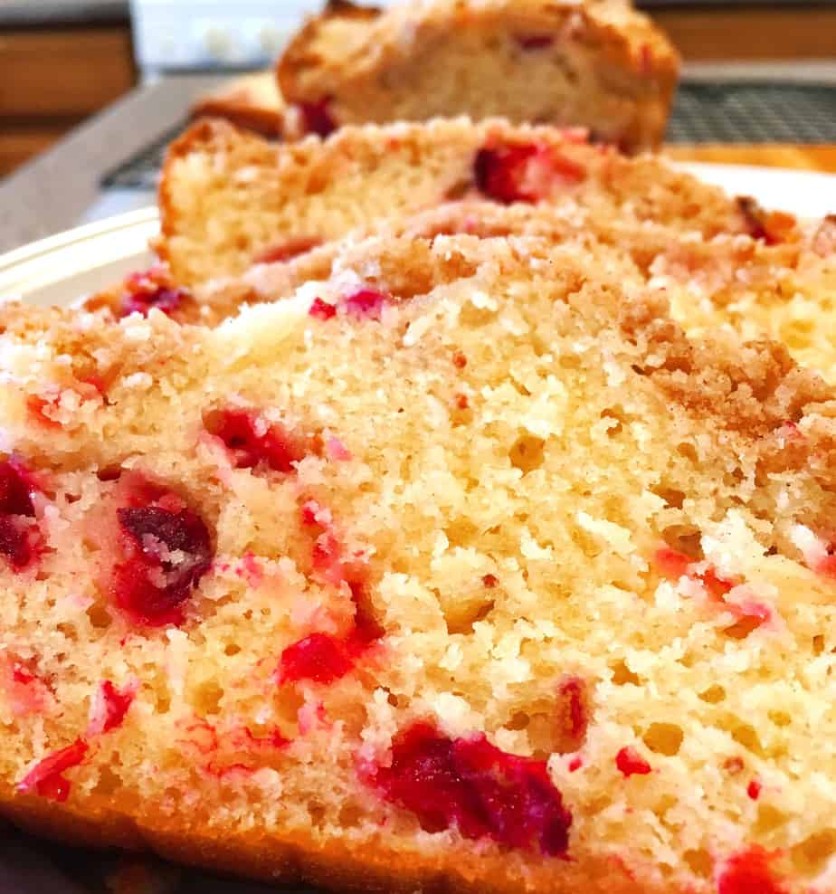 cranberry orange bread topped with crumb topping and orange drizzle