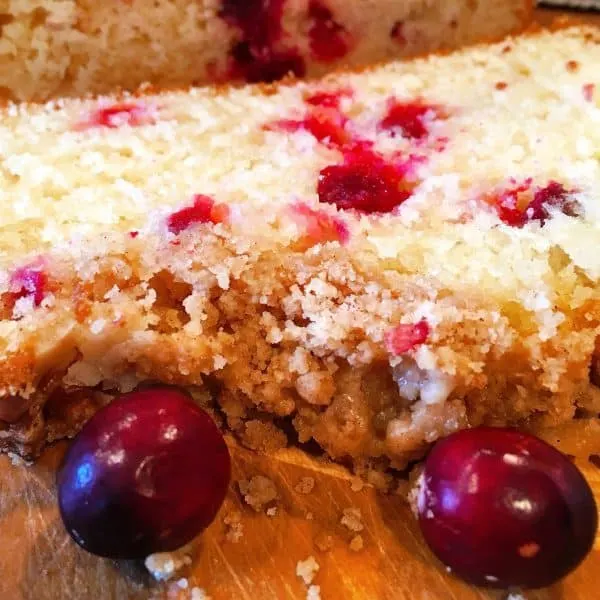 Slices of Cranberry Orange Bread with crumb topping and orange drizzle.