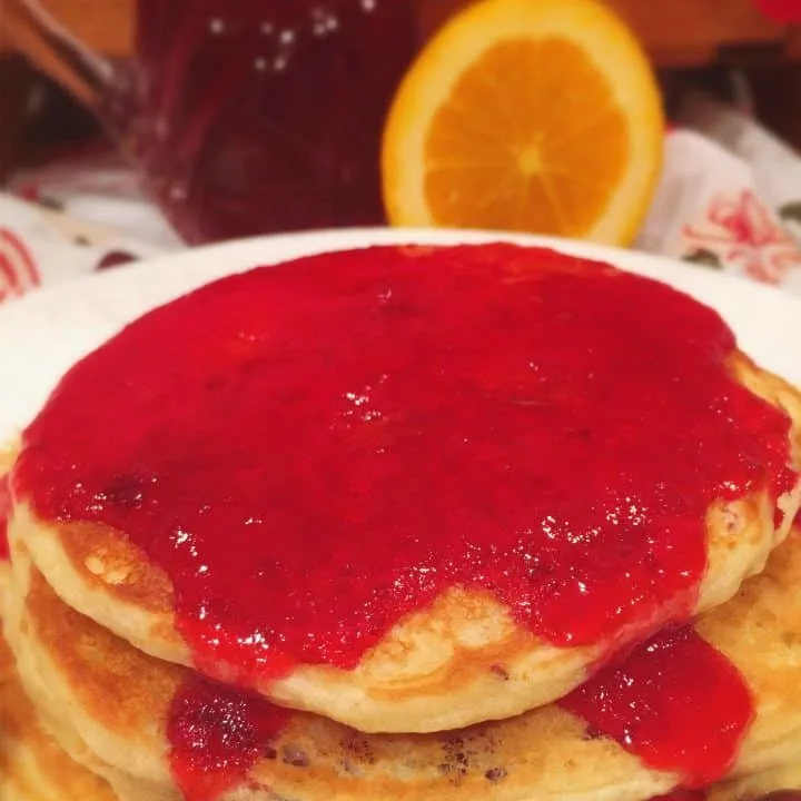 Cranberry Orange Pancakes in a stack with syrup
